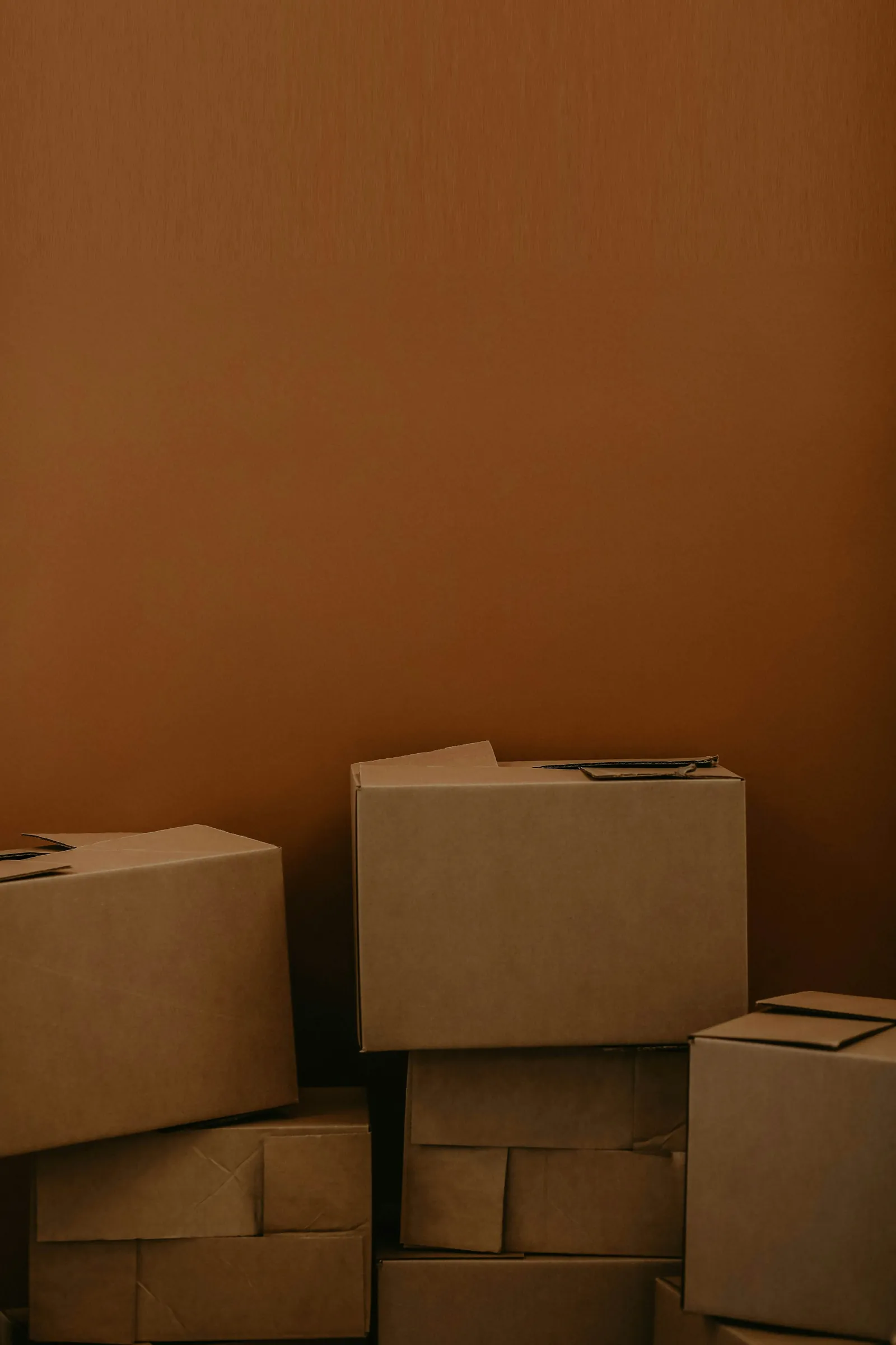 Plain cardboard boxes stacked against a wall