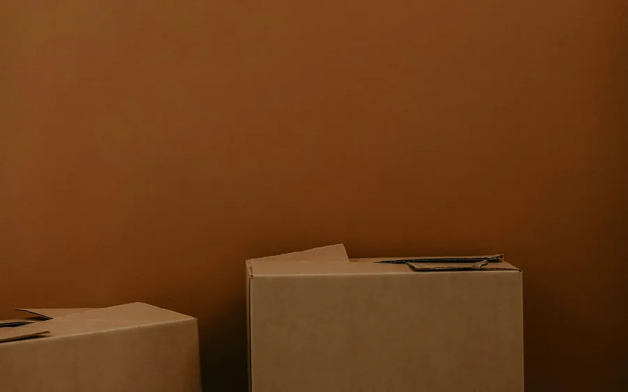 Plain cardboard boxes stacked against a wall