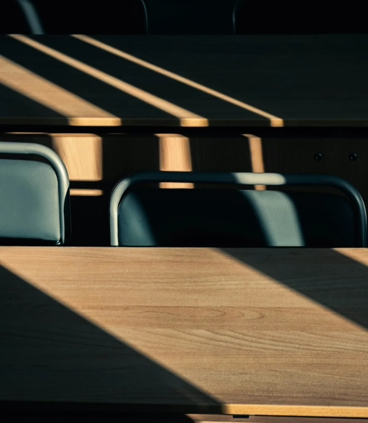 Daylight through blinds across empty desks