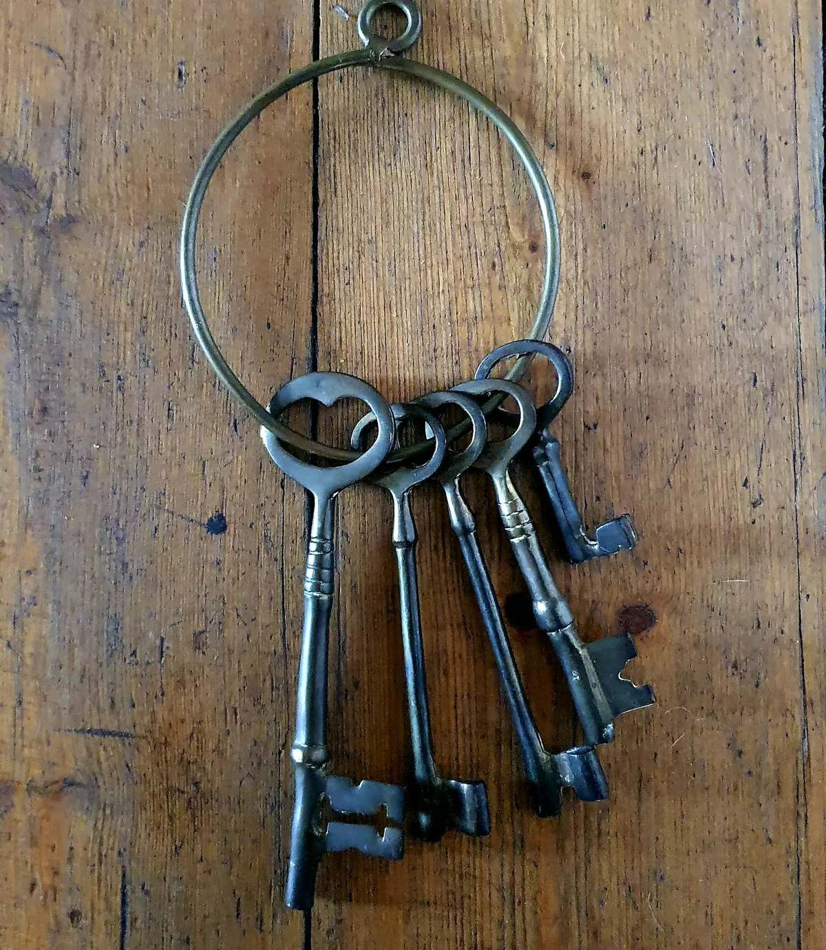 A ring of old keys on a wooden table