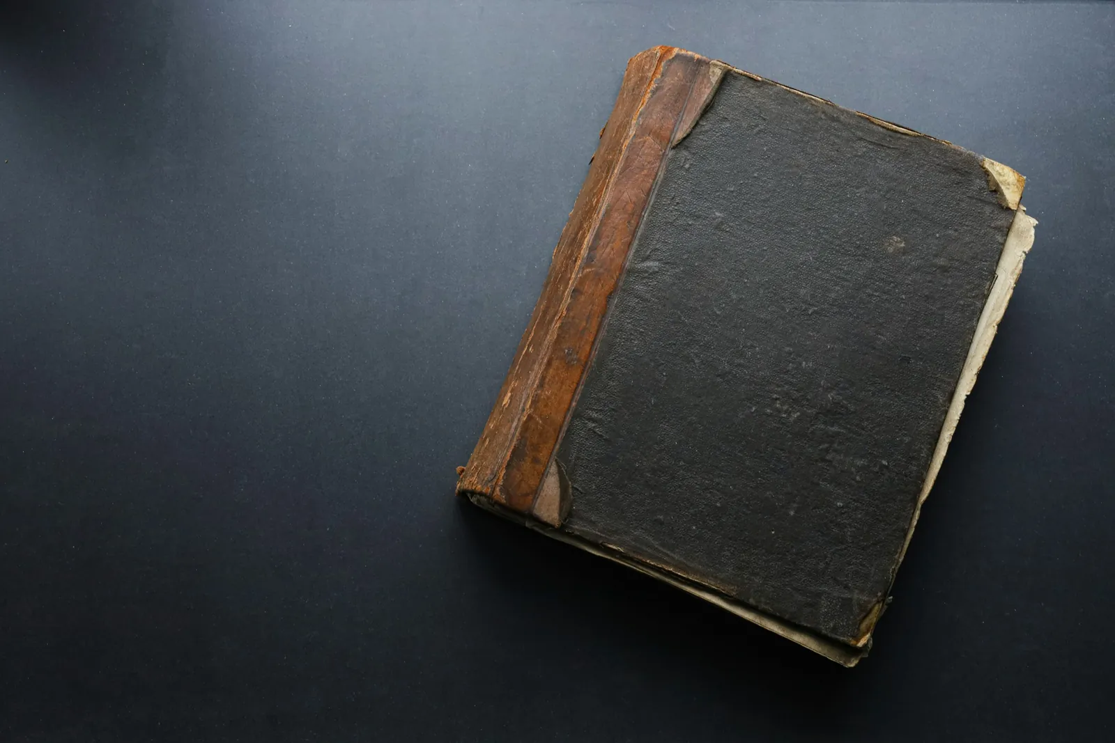 A worn ledger on a dark table