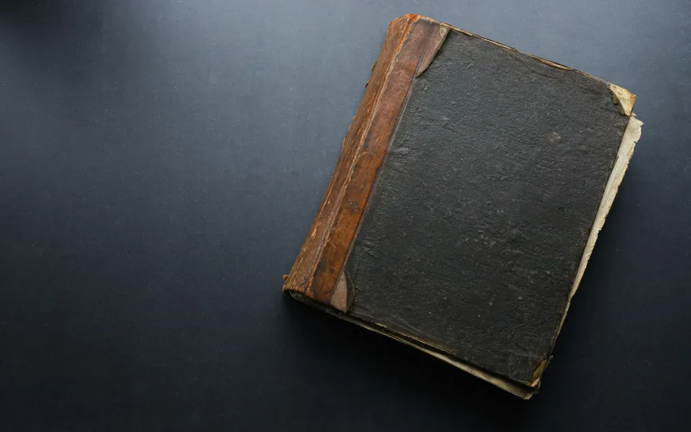 A worn ledger on a dark table